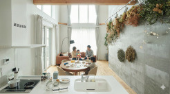 「光と緑に包まれる、家族のリビング時間」

大きな吹き抜けからやわらかな自然光が差し込む、開放感あふれるLDK。キッチンからリビングまで一直線に広がる空間には、木の温もりと上質なインテリアが調和しています。